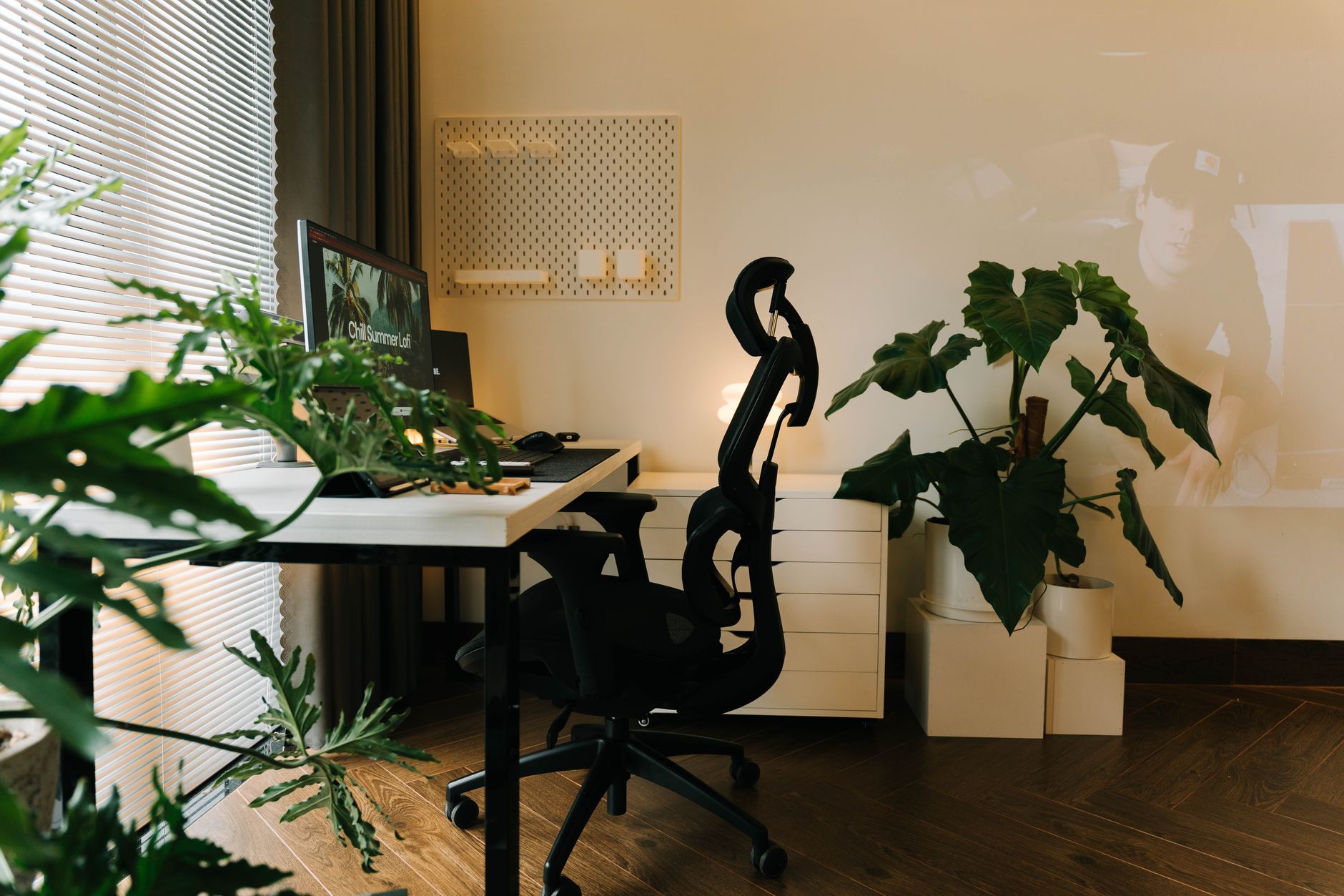 Een stijlvol thuiskantoor met planten en een ergonomische stoel, ingericht voor productief werken.